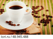 Vintage background with coffee cup and coffee beans  on green bamboo stand. Стоковое фото, агентство Ingram Publishing / Фотобанк Лори