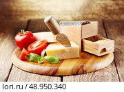 parmesan cheese with grater on wooden background. Стоковое фото, агентство Ingram Publishing / Фотобанк Лори