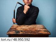 Angry man at table with nunchucks . Стоковое фото, агентство Ingram Publishing / Фотобанк Лори