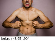 Athletic young man flexing his muscles. Стоковое фото, агентство Ingram Publishing / Фотобанк Лори