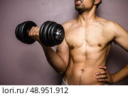 Athletic young man working out with dumbbell. Стоковое фото, агентство Ingram Publishing / Фотобанк Лори