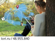 Concept of sitting young woman using her tablet pc during rest in the park. Стоковое фото, агентство Ingram Publishing / Фотобанк Лори