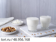Kefir, buttermilk or yogurt, cottage cheese with granola. Yogurt in glass on white wooden background. Стоковое фото, фотограф Наталия Попова / Фотобанк Лори