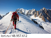 Mountaneer climbs a snowy ridge in Mont Blanc, France. Enterprise, diligence, team work: mountaneering concepts. Стоковое фото, агентство Ingram Publishing / Фотобанк Лори