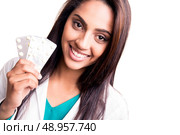 Beautiful brunette doctor showing sealed blisters over white. Стоковое фото, агентство Ingram Publishing / Фотобанк Лори