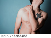 Young man is in pain and is massasing his sore neck. Стоковое фото, агентство Ingram Publishing / Фотобанк Лори