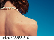 A young woman is tanning her back on a sunny day with a clear blue sky. Стоковое фото, агентство Ingram Publishing / Фотобанк Лори