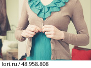 A young woman is buttoning her blouse. Стоковое фото, агентство Ingram Publishing / Фотобанк Лори
