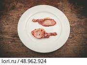 Two rashers of bacon on a white plate. Стоковое фото, агентство Ingram Publishing / Фотобанк Лори