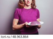 A young woman in a purple top is holding a pudding. Стоковое фото, агентство Ingram Publishing / Фотобанк Лори