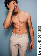 laughing shirtless man with his hand on his face. Стоковое фото, агентство Ingram Publishing / Фотобанк Лори