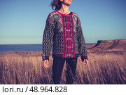 Woman standing in a field by the sea at sunset. Стоковое фото, агентство Ingram Publishing / Фотобанк Лори