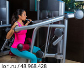 Lat Lateral dorsal pulldown machine upper back exercises woman at gym workout. Стоковое фото, агентство Ingram Publishing / Фотобанк Лори