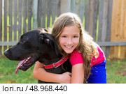 great dane and kid girl hug playing together at backyard outdoor. Стоковое фото, агентство Ingram Publishing / Фотобанк Лори