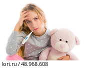 blond girl with thermometer and flu cold in pyjama  grumpy face with teddy bear. Стоковое фото, агентство Ingram Publishing / Фотобанк Лори