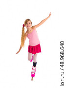 blond pigtails roller skate girl full length dancing balance on white background. Стоковое фото, агентство Ingram Publishing / Фотобанк Лори