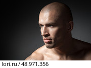 portrait of strong man isolated on dark background. Стоковое фото, агентство Ingram Publishing / Фотобанк Лори