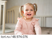 Little Girl joking sticking tongue out with silly expression. Child making face. Funny foolishness portrait of baby girl laughing in bedroom. Adorable Caucasian kid doing crazy comical gesture at home. Стоковое фото, фотограф Марина Демидюк / Фотобанк Лори