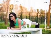 Fitness woman doing exercises in the city park. Стоковое фото, агентство Ingram Publishing / Фотобанк Лори