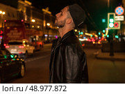 City Lights and Contemplation A Young Man Gaze Upward at Night in London. Стоковое фото, фотограф Aleksandr Golubev / Фотобанк Лори