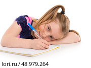 Blond kid indented girl student with spiral notebook in pupil desk. Стоковое фото, агентство Ingram Publishing / Фотобанк Лори