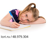 Blond kid indented girl student with spiral notebook in pupil desk. Стоковое фото, агентство Ingram Publishing / Фотобанк Лори