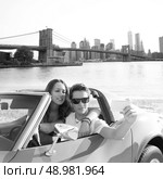 selfie of young teen couple at convertible car in New York Brooklyn Bridge photo mount. Стоковое фото, агентство Ingram Publishing / Фотобанк Лори