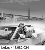 selfie of young teen couple at convertible car in San Francisco Golden Gate Bridge photo mount. Стоковое фото, агентство Ingram Publishing / Фотобанк Лори