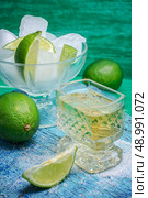 glass alcoholic drink and lime fruits on wooden texture.Selective focus. refreshing cocktail made of rum and lime with ice. Стоковое фото, агентство Ingram Publishing / Фотобанк Лори
