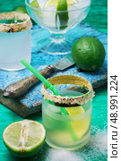 glass alcoholic drink and lime fruits on wooden texture.Selective focus. refreshing cocktail made of rum and lime with ice. Стоковое фото, агентство Ingram Publishing / Фотобанк Лори