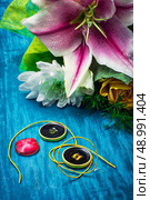 sewing accessories with a bouquet of fresh flowers on turquoise background. Стоковое фото, агентство Ingram Publishing / Фотобанк Лори