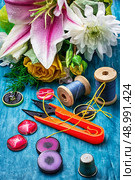sewing accessories with a bouquet of fresh flowers on turquoise background. Стоковое фото, агентство Ingram Publishing / Фотобанк Лори