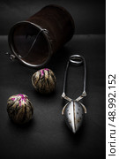 dry leaves of the tea infuser and accessories on black background. spilled tea . Стоковое фото, агентство Ingram Publishing / Фотобанк Лори