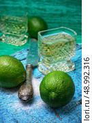 glass alcoholic drink and lime fruits on wooden texture.Selective focus. alcoholic cocktail with additions of lime. Стоковое фото, агентство Ingram Publishing / Фотобанк Лори