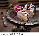 chopped baked dessert on the background of the tea infuser. sweet roll on the iron tray and brew tea in glass. Стоковое фото, агентство Ingram Publishing / Фотобанк Лори