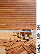 Ipe wood fence installation with carpenter table circular saw and sawdust. Стоковое фото, агентство Ingram Publishing / Фотобанк Лори