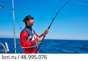 Beard sailor man fishing rod trolling in saltwater in a boat trolling with captain cap. Стоковое фото, агентство Ingram Publishing / Фотобанк Лори