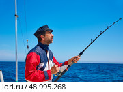Beard sailor man fishing rod trolling in saltwater in a boat trolling with captain cap. Стоковое фото, агентство Ingram Publishing / Фотобанк Лори