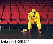 the man in a protective coverall  sitting in an empty theater. Creative concept. Стоковое фото, агентство Ingram Publishing / Фотобанк Лори
