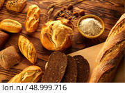 Bread fresh varied mix on golden rustic wood golden table. Стоковое фото, агентство Ingram Publishing / Фотобанк Лори