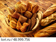 Bread fresh varied mix on golden rustic wood in basket. Стоковое фото, агентство Ingram Publishing / Фотобанк Лори