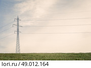Tall pylons with wires on a green field. Стоковое фото, агентство Ingram Publishing / Фотобанк Лори