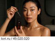 Азиатская женщина с сывороткой для лица: красота, уход за кожей и здоровье. Стоковое AI-изображение, AI-художник Оксана Хорватич / Фотобанк Лори