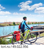 MTB Biker Bicycle touring on the river with pannier racks and saddlebag. Стоковое фото, агентство Ingram Publishing / Фотобанк Лори
