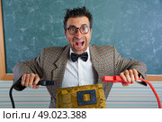 Nerd electronics technician retro teacher silly expression with big battery clamps in pcb. Стоковое фото, агентство Ingram Publishing / Фотобанк Лори