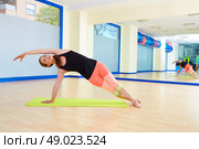 Pilates woman side bend exercise workout at gym indoor. Стоковое фото, агентство Ingram Publishing / Фотобанк Лори