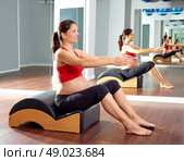 pregnant woman pilates exercise with spine wave corrector. Стоковое фото, агентство Ingram Publishing / Фотобанк Лори