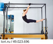 Pilates woman in cadillac acrobatic reformer exercise at gym. Стоковое фото, агентство Ingram Publishing / Фотобанк Лори