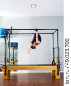 Pilates woman in cadillac acrobatic upside down balance reformer exercise at gym. Стоковое фото, агентство Ingram Publishing / Фотобанк Лори