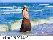 Pregnant woman on the beach playing with waves. Стоковое фото, агентство Ingram Publishing / Фотобанк Лори